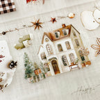 Decorative house card with Christmas elements on a textured surface
