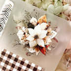 Decorative clear stamp with floral design on a checkered surface