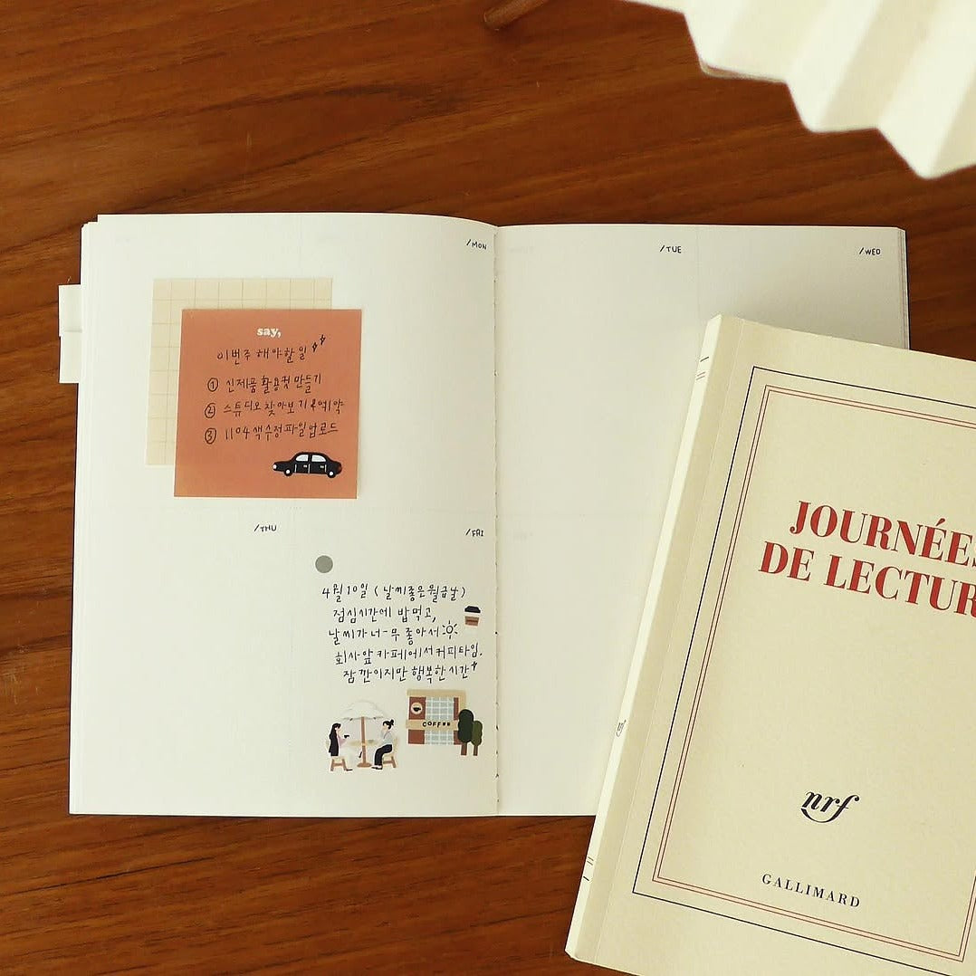 Open book with illustrations on a wooden surface, from the City!City! Sticker Sheet