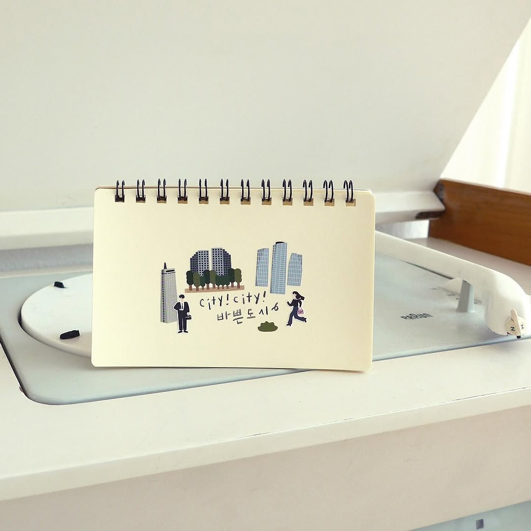 Small notebook with city-themed illustrations on a desk, from the City!City! Sticker Sheet