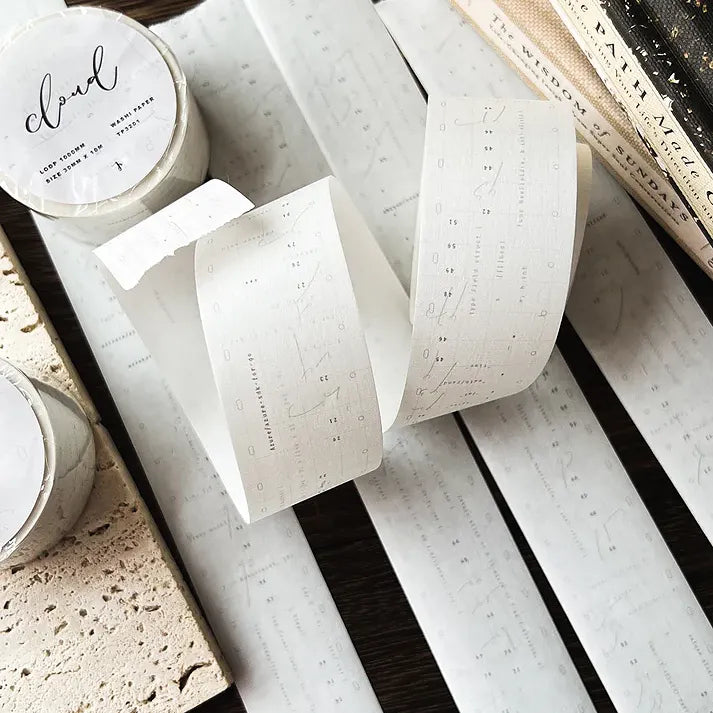 Rolls of Cloud Washi Tape with retro programming-style text on a textured surface, close-up view