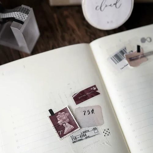 Open notebook styled with Cloud Washi Tape stamp designs and a pen on a warm wooden surface