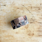 Metal money clip with photo collage on a wooden surface