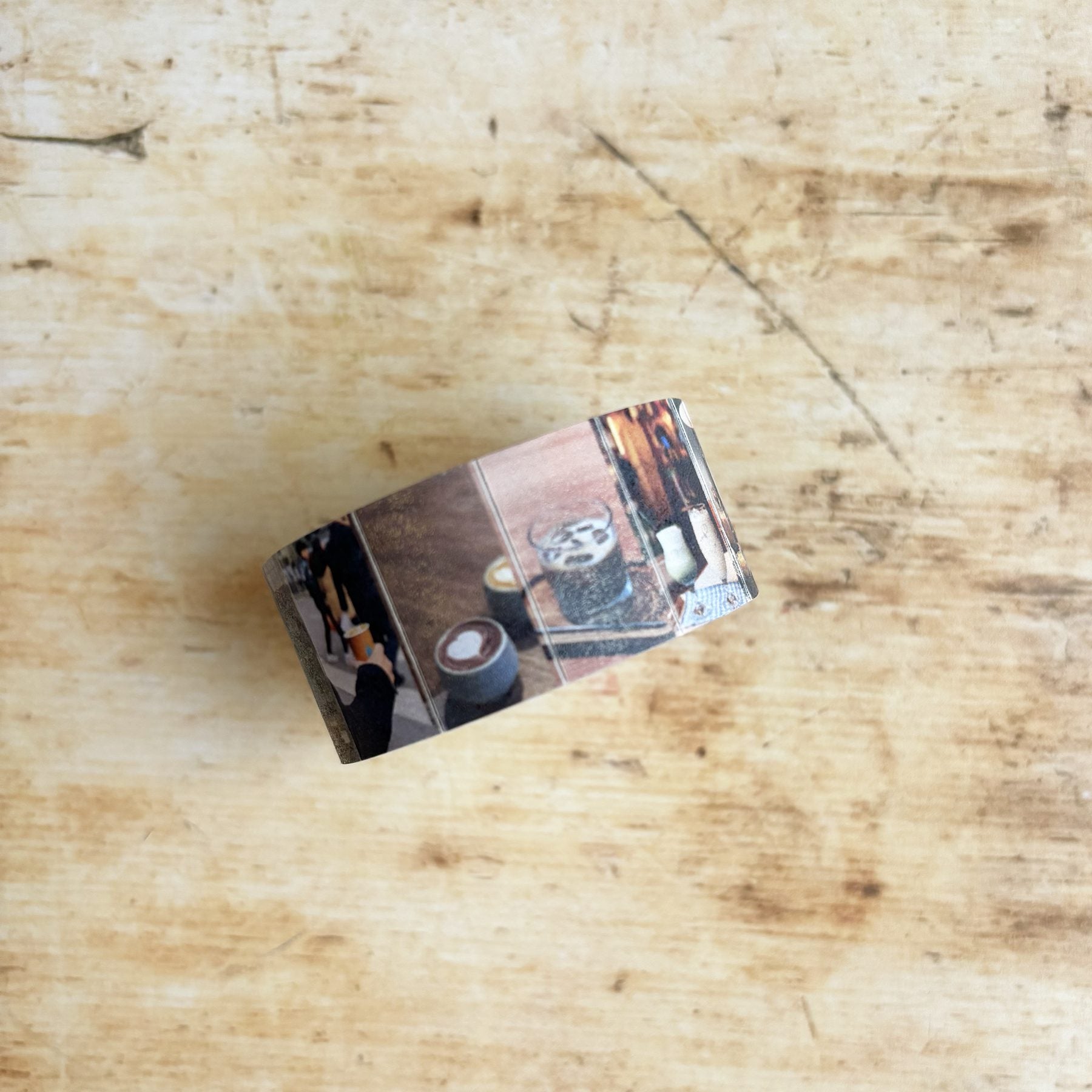 Metal money clip with photo collage on a wooden surface