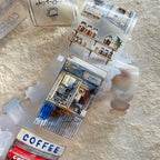 Miniature model of a coffee shop with various coffee-themed items on a textured surface.