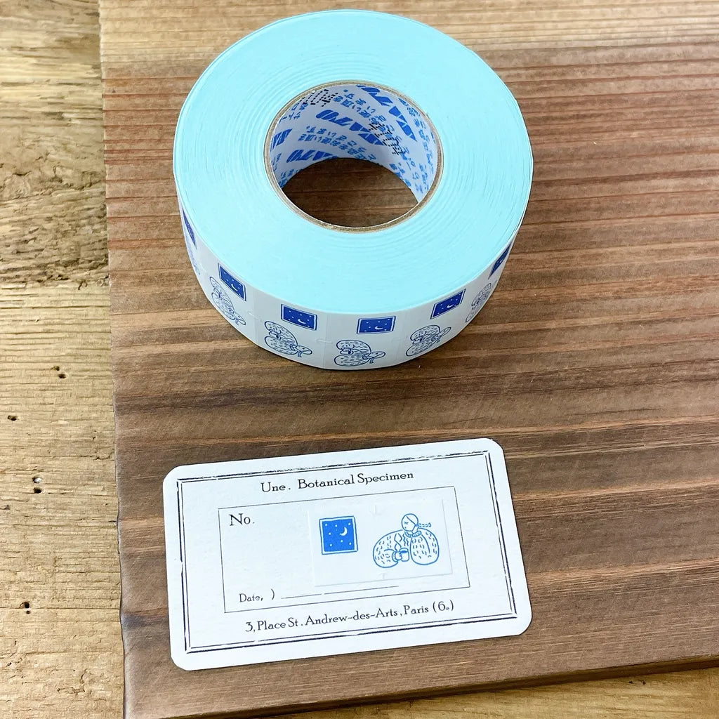 Roll of blue tape with a label on a wooden surface