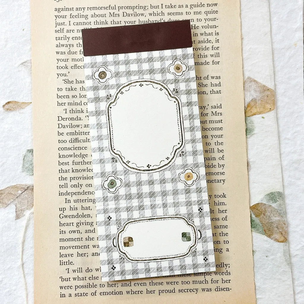Decorative bookmark with checkered pattern on a textured surface