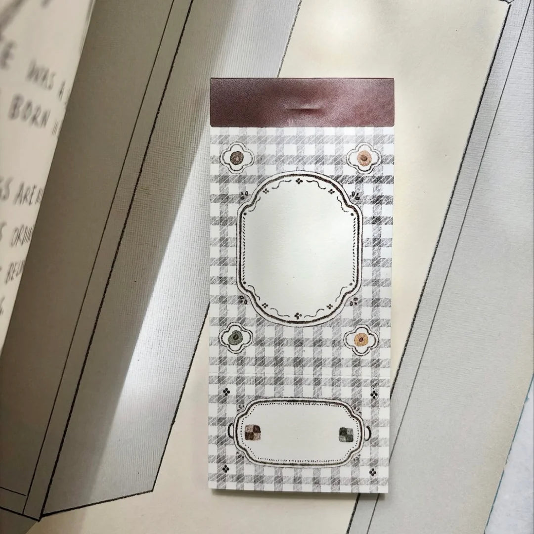 Decorative card with plaid pattern and decorative elements on a plain background