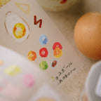 Eggs on a surface with a colorful object and text in the background