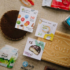 Stamps with cartoon designs on a textured surface with a biscuit and other items.