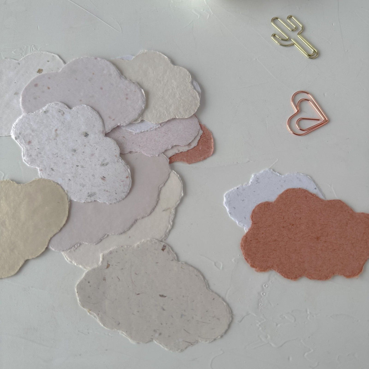 Cotton Cloud Handmade Paper cloud shapes scattered with decorative paper clips, styled detail view