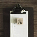 Clipboard with a calendar and rubber stamp on a wooden surface