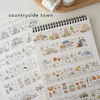 Notebook with countryside town design on a light background