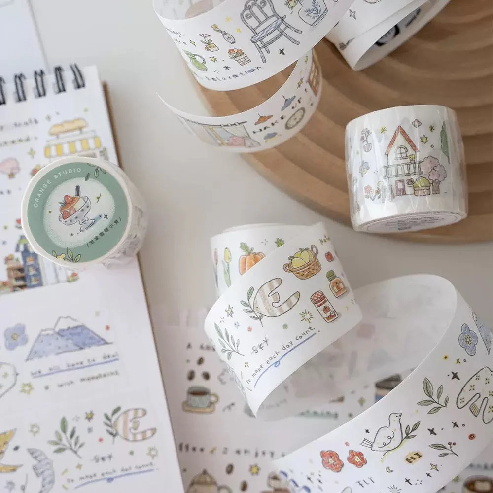 Decorative tape rolls with cute illustrations on a white surface