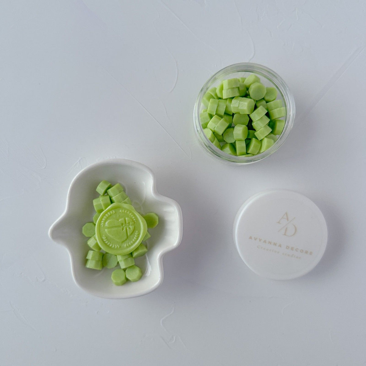 Cucumber Cooler Wax Beads shown in a glass jar and small white dish together on a light grey backdrop
