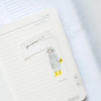Passers-By Sticker Set by Dodolulu — coat-and-boots figure sticker in a notebook, for journaling