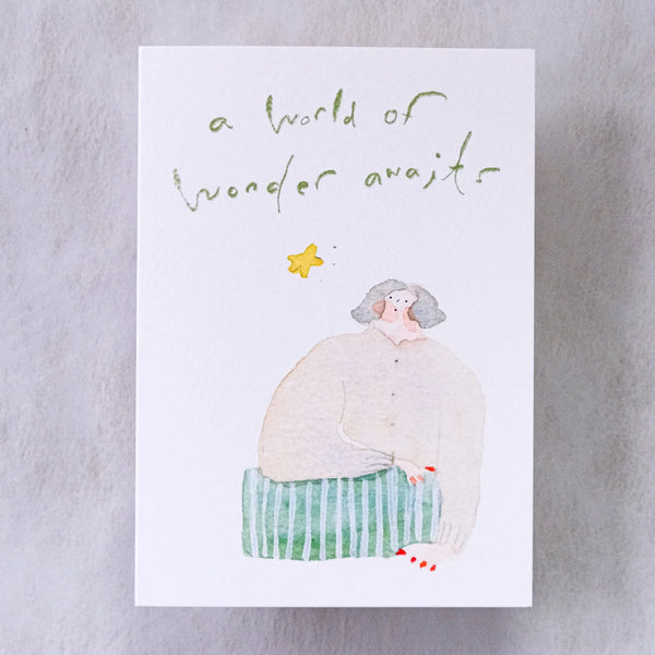 Wonder Awaits Greeting Card by Dodolulu — figure and 'a world of wonder awaits' text on grey, for gifting