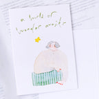 Wonder Awaits Greeting Card by Dodolulu — figure holding a star, wonder-awaits card on white, for gifting