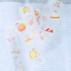 Seasons Quartet Vol.1 PET Tape by Dodolulu — character PET tape roll on a book page, for journaling