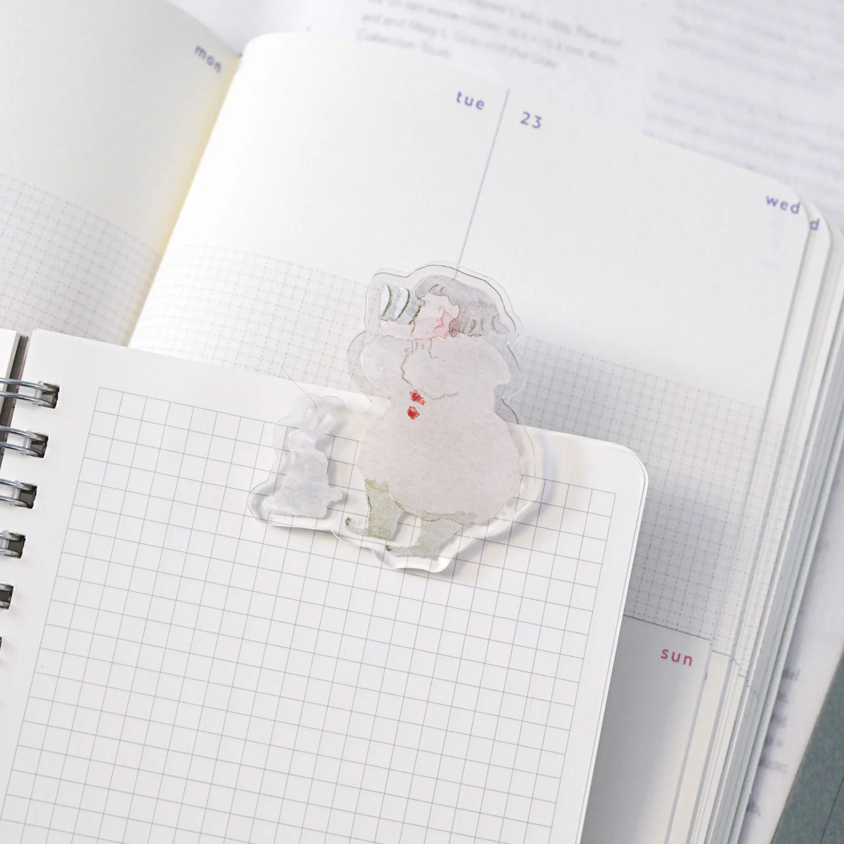 Telescope Journaling Clip by Dodolulu — clear acrylic sleepy-character clip on grid notebooks, for journaling