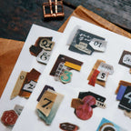 Collection of decorative paper pieces with numbers and letters on a white surface.