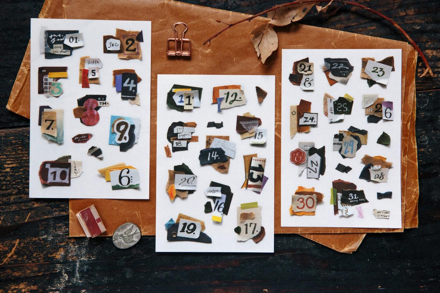 Three sheets of decorative stickers with numbers and various designs on a wooden surface.