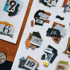 Scattered pieces of paper with numbers and text on a white surface