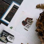 Decorative stamps with numbers and letters on a piece of paper with grid lines.