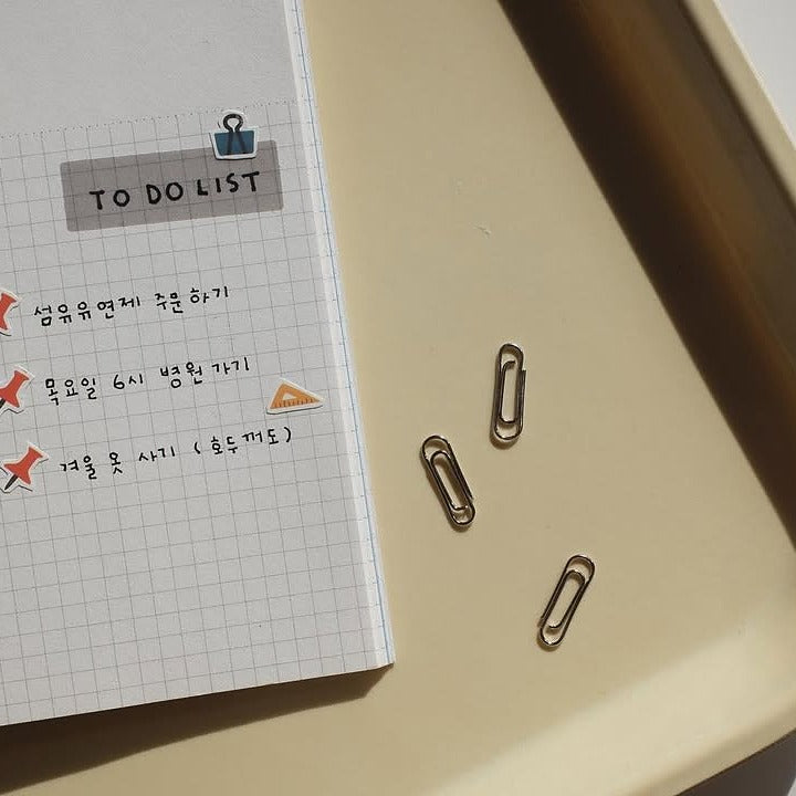 Notebook with a to-do list and paper clips on a beige surface, from the Deco 07 Sticker Sheet