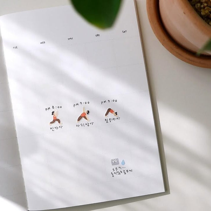 Notebook with yoga-themed illustrations on a white surface, from the Deco 15 Sticker Sheet