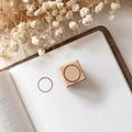 Wooden stamp on a notebook with dried flowers in the background