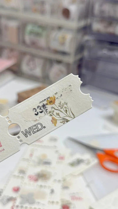 Decorative paper cutout with 'WED.' text on a blurred background