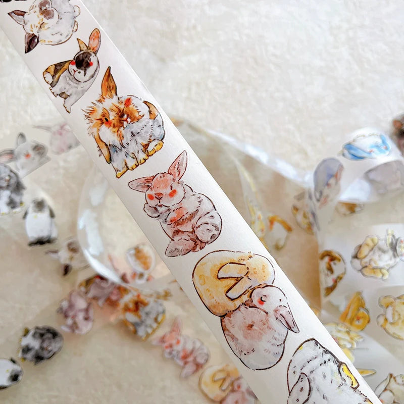 Roll of Cute Rabbit Ji A34 PET Tape by DingDing with rabbit artwork on a textured surface