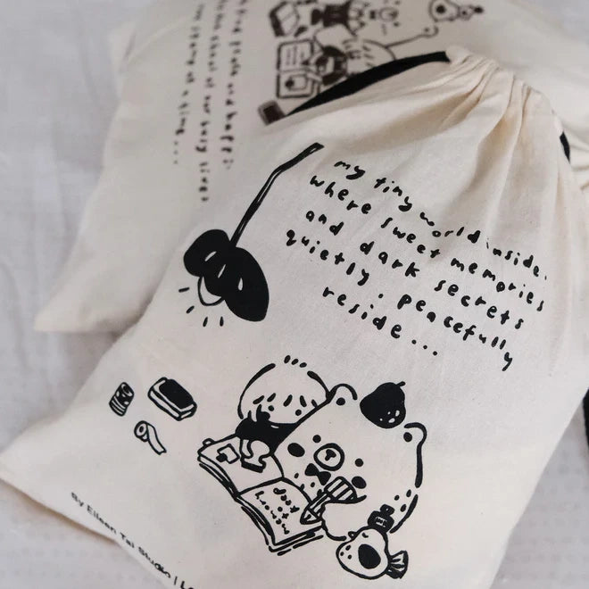 Black One Stamp at a Time Drawstring Pouch with black illustrations and text on a white backdrop
