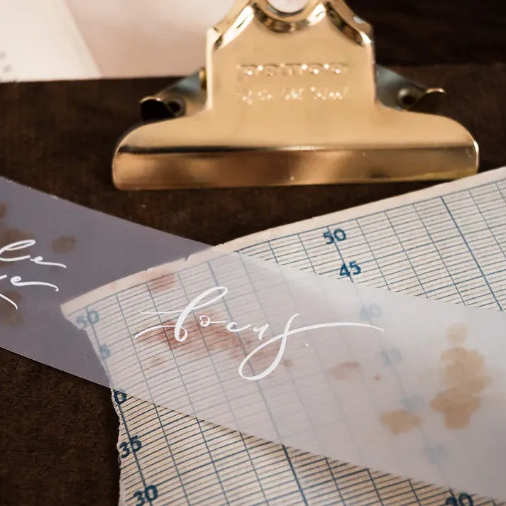Gold clip holding a paper decorated with Dream Time Calligraphy PET Tape script styled beside a ruler