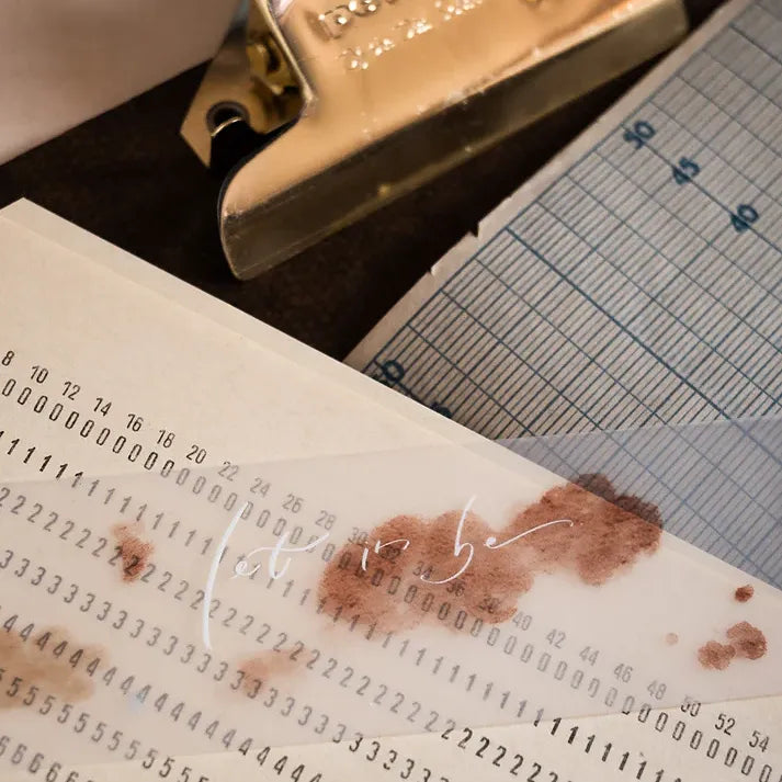 Dream Time Calligraphy PET Tape design on a document in a styled desk scene with a stapler and chart