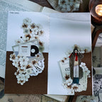 Decorative book with floral and person illustrations on a wooden surface.