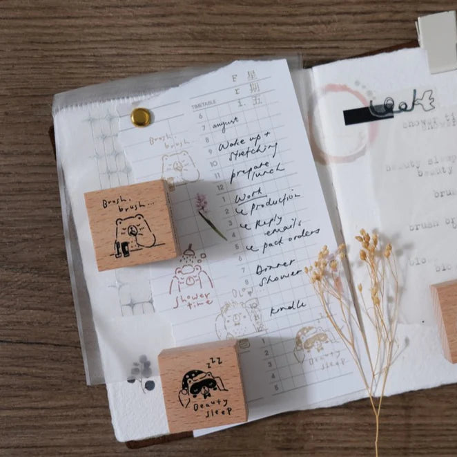 Open notebook styled with Beary Ordinary Days 04 stamps and a pen on a wooden surface