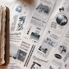 Collection of black and white stickers with text and graphics on a textured surface.