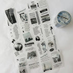 Collection of black and white decorative paper sheets with text and graphics on a white surface.
