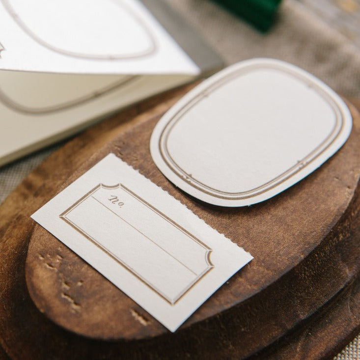 Ellipse Label Letterpress Book by OURS Studio styled with a carved wooden stamp on texture