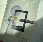 Notebook with stickers and a yellow flower on a textured surface