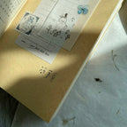 Close-up of a yellowed book with decorative elements on a textured surface