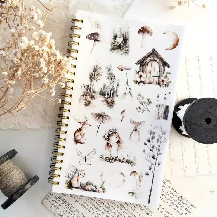 Notebook decorated with Enchanted Forest PET Tape nature stickers on a textured surface