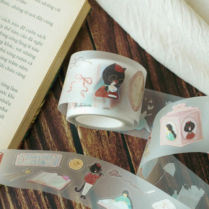 Enchanted Library PET Tape cat and camera illustrations on a wooden surface with an open book