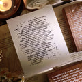 Sheet of paper with text on a book with a candle in the background
