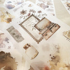 Collection of vintage-style stickers with a perfume bottle, camera, and text on a textured surface.