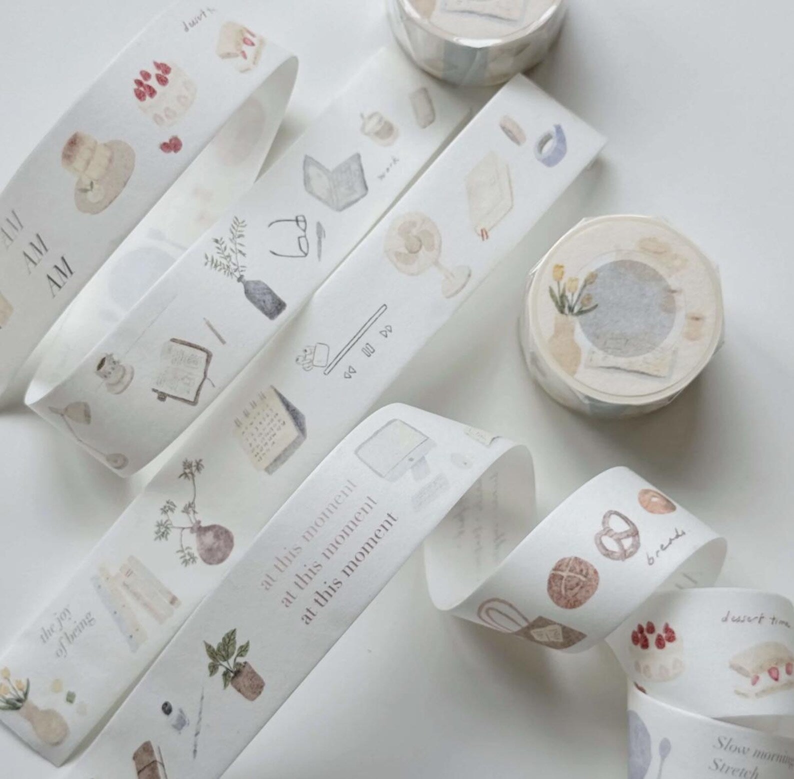 Decorative washi tape rolls with various designs on a light background