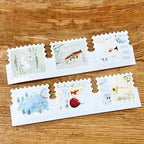 Decorative envelopes with artistic designs on a wooden surface