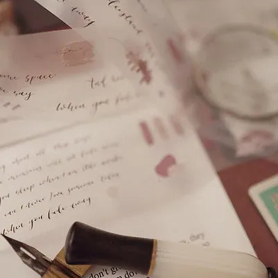 Inkwell with quill pen on a piece of paper with handwritten text